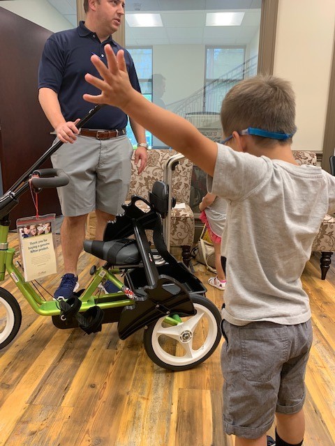 caleb receiving bike, stroller from variety the children's charity